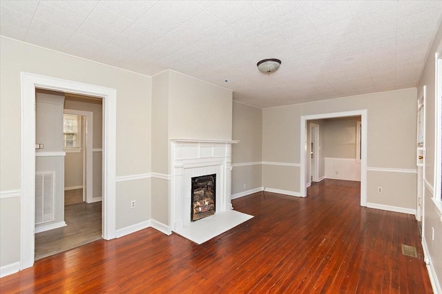 unfurnished living room with dark hardwood / wood-style floors and a brick fireplace