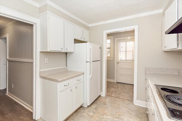 kitchen with cooktop, white cabinets, white fridge, and ornamental molding