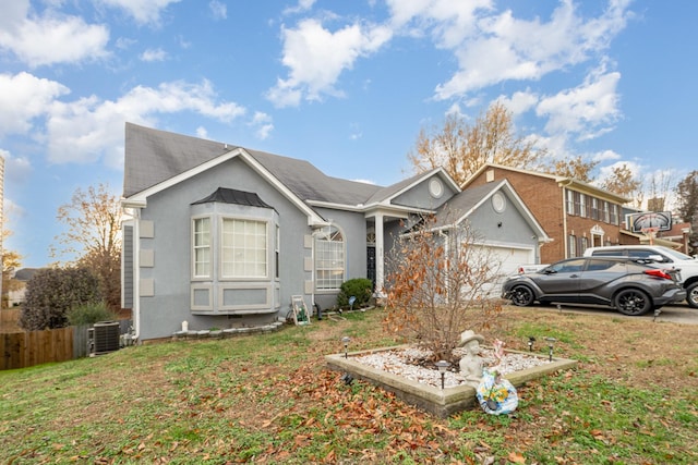 view of front of house with central air condition unit, a front yard, and a garage