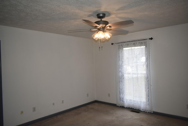 spare room featuring dark carpet and ceiling fan