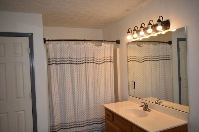 bathroom with vanity, a textured ceiling, and curtained shower