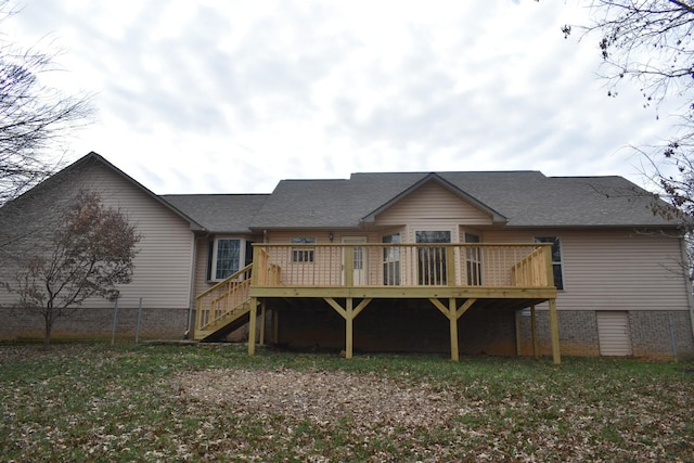 back of property with a deck and a lawn