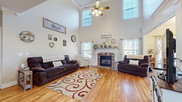 living room with light hardwood / wood-style floors, ornamental molding, and a wealth of natural light