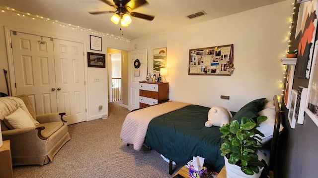 carpeted bedroom with ceiling fan and a closet