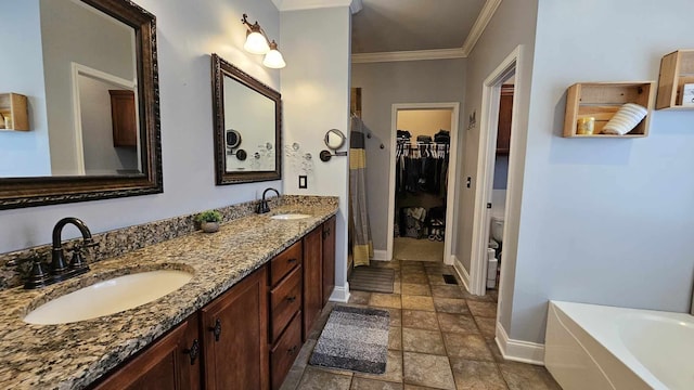 bathroom with a tub to relax in, toilet, vanity, and ornamental molding