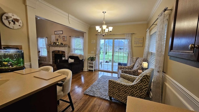 sitting room with crown molding, dark wood-type flooring, and an inviting chandelier