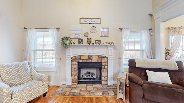 living room with a stone fireplace and light hardwood / wood-style flooring