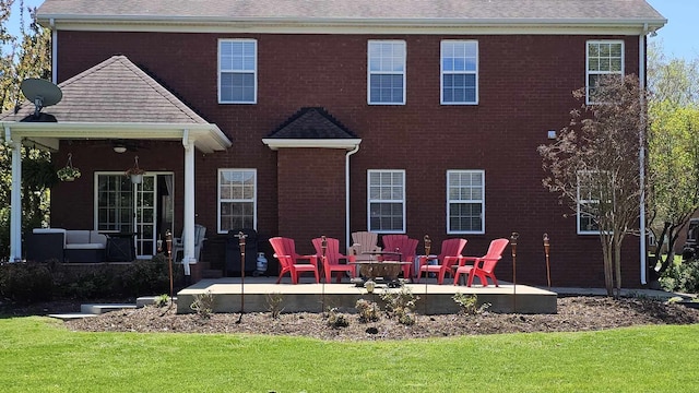 rear view of property featuring a yard and a patio