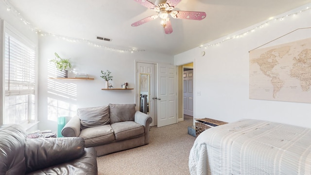 carpeted bedroom with ceiling fan and multiple windows