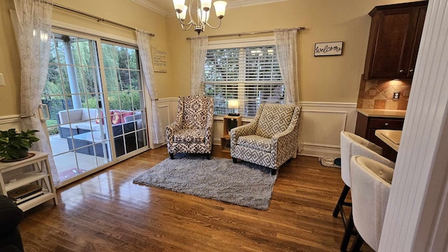 sitting room featuring a notable chandelier, dark hardwood / wood-style flooring, and crown molding