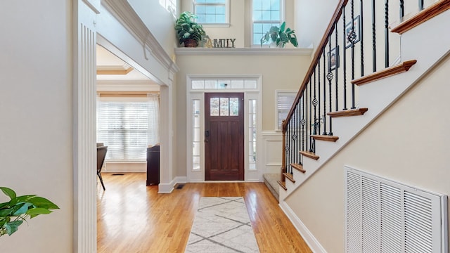 foyer entrance featuring light wood-type flooring and a high ceiling