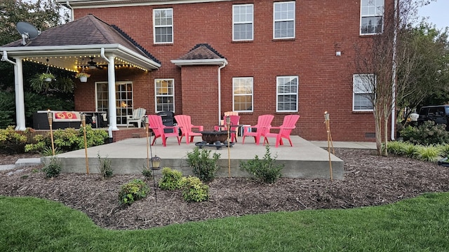 rear view of property featuring a fire pit, ceiling fan, and a patio area