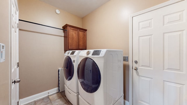 washroom featuring washer and dryer, light tile patterned floors, and cabinets