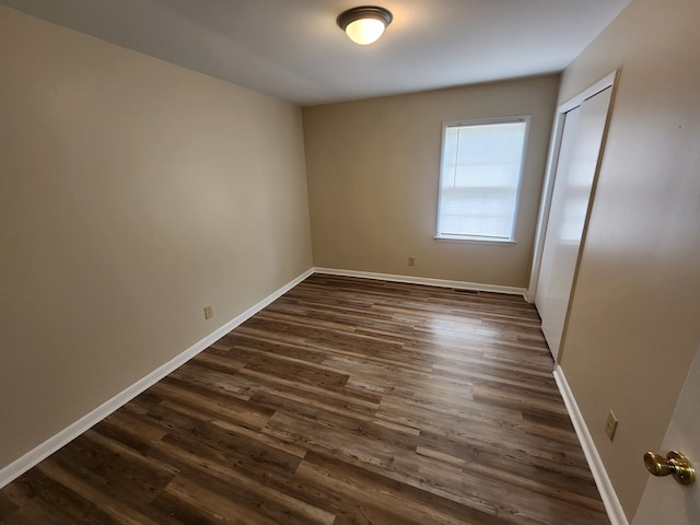 empty room with dark hardwood / wood-style flooring