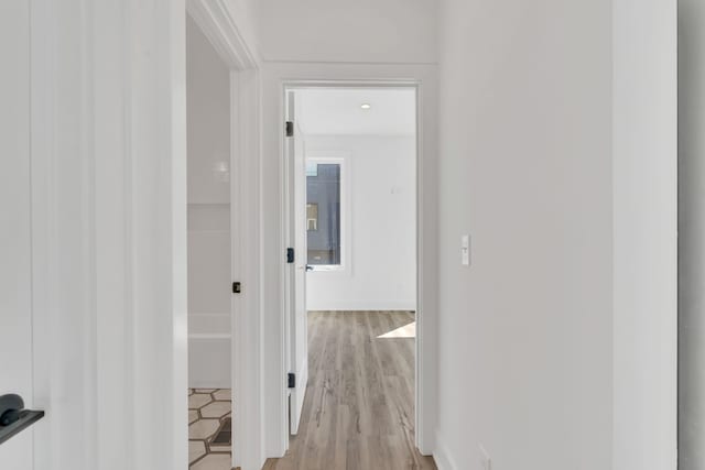 hallway with light hardwood / wood-style flooring