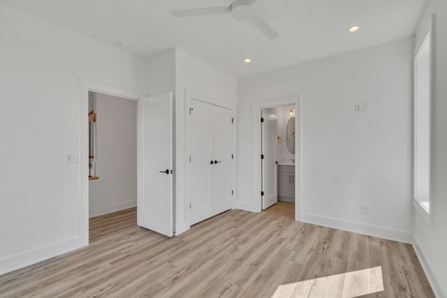 unfurnished bedroom with a closet, ensuite bathroom, light hardwood / wood-style flooring, and ceiling fan