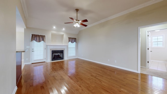 unfurnished living room featuring ceiling fan, light wood-type flooring, and ornamental molding