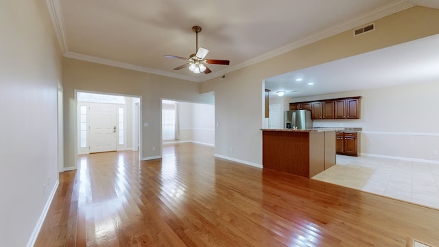 unfurnished living room with ceiling fan, ornamental molding, and light wood-type flooring