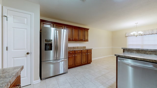 kitchen with light tile patterned floors, stainless steel appliances, an inviting chandelier, and hanging light fixtures