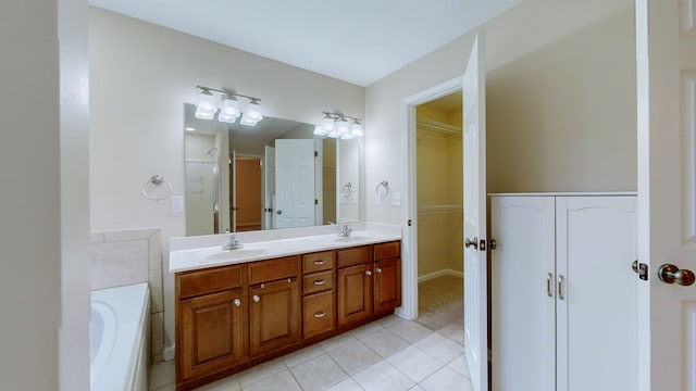 bathroom with tile patterned floors, a tub, and vanity