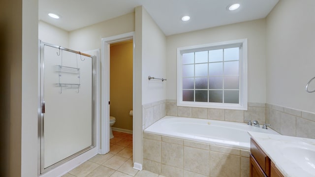 full bathroom with tile patterned floors, vanity, shower with separate bathtub, and toilet