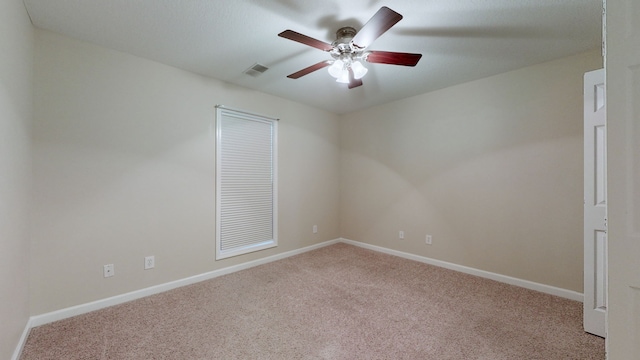 spare room with ceiling fan and light colored carpet