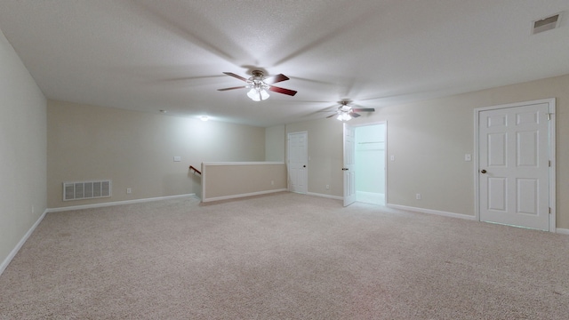 carpeted empty room featuring ceiling fan and a textured ceiling