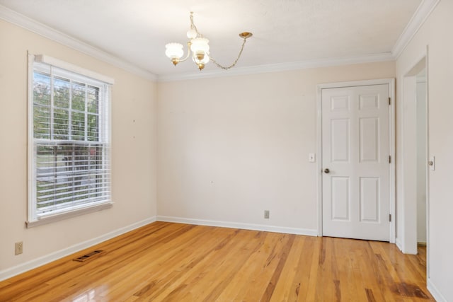 spare room featuring ornamental molding, wood-type flooring, and a notable chandelier