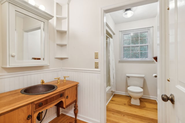 full bathroom with shower / bath combination with curtain, built in shelves, vanity, hardwood / wood-style flooring, and toilet