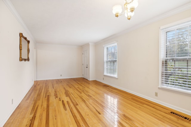 spare room featuring crown molding, a healthy amount of sunlight, and wood-type flooring