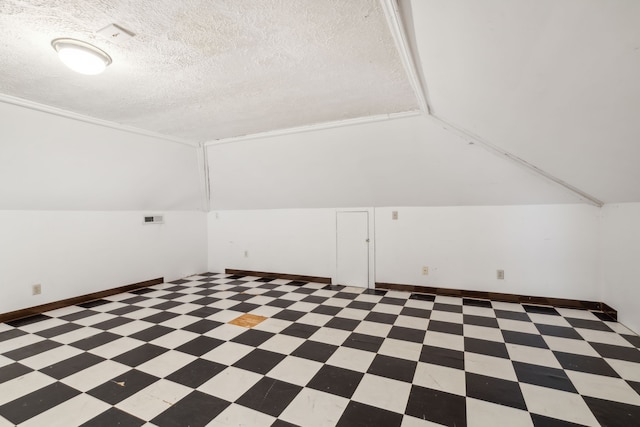 bonus room with lofted ceiling and a textured ceiling