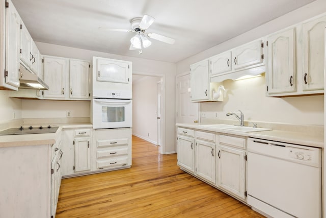 kitchen featuring sink, white cabinets, light hardwood / wood-style floors, and white appliances