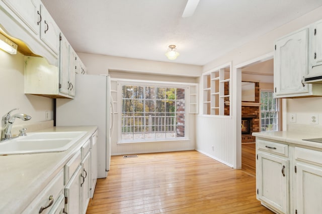 kitchen with white cabinetry, light hardwood / wood-style flooring, plenty of natural light, and sink