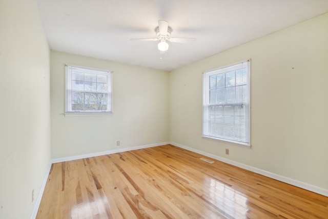 unfurnished room featuring ceiling fan, plenty of natural light, and light wood-type flooring