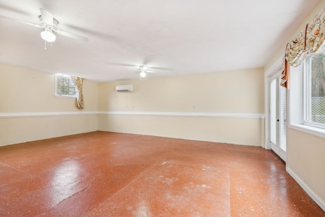 spare room featuring a wall unit AC, ceiling fan, and concrete floors