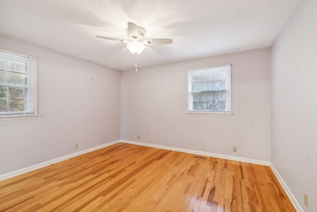 spare room featuring light hardwood / wood-style floors, plenty of natural light, and ceiling fan