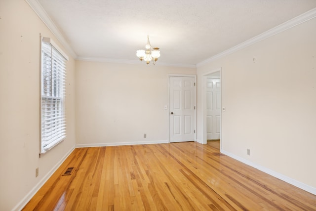 unfurnished room featuring a textured ceiling, light wood-type flooring, ornamental molding, and an inviting chandelier