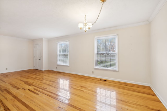 unfurnished room featuring wood-type flooring, ornamental molding, and a notable chandelier