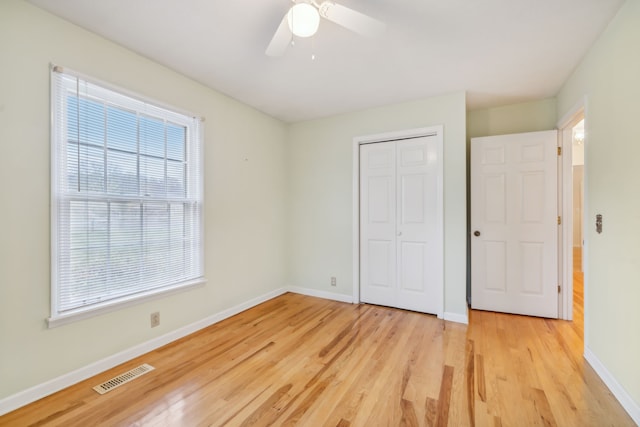 unfurnished bedroom with ceiling fan, a closet, and light wood-type flooring