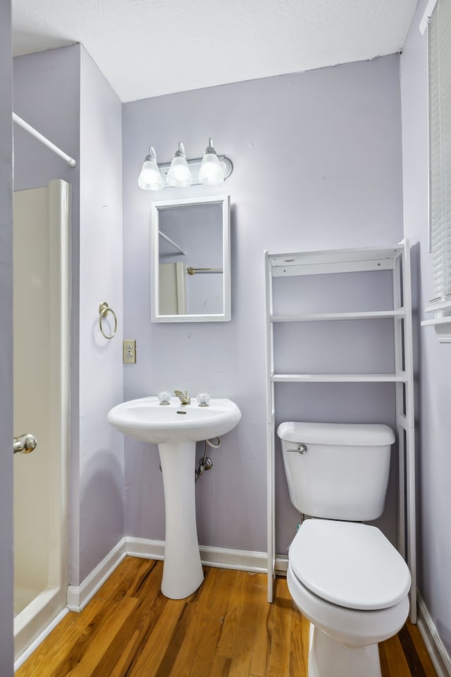 bathroom with hardwood / wood-style floors, toilet, and sink