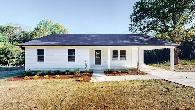 ranch-style home featuring a carport, covered porch, and a front yard