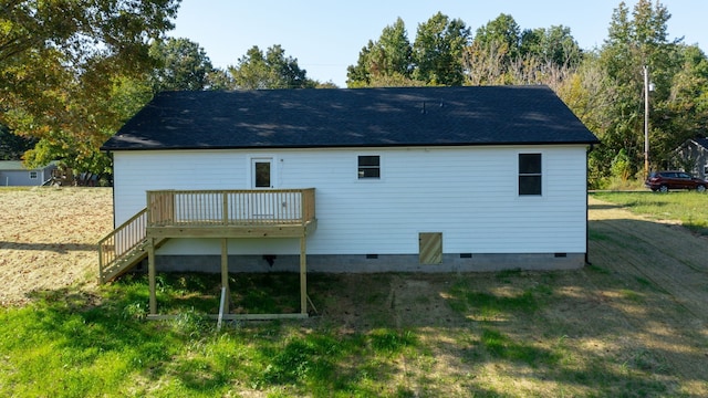 back of property featuring a lawn and a deck