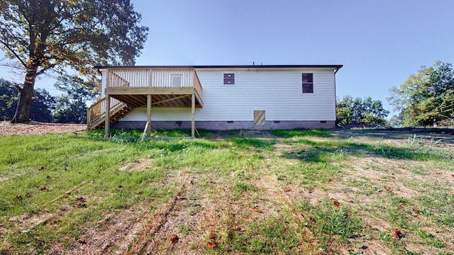 rear view of property featuring a lawn and a wooden deck