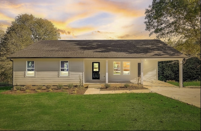 view of front facade with a carport and a lawn