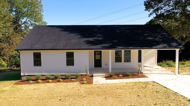 view of front facade with a front yard, a porch, and a carport