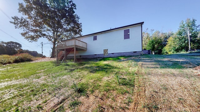 rear view of house with a yard and a deck