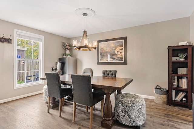 dining room with hardwood / wood-style flooring and a notable chandelier