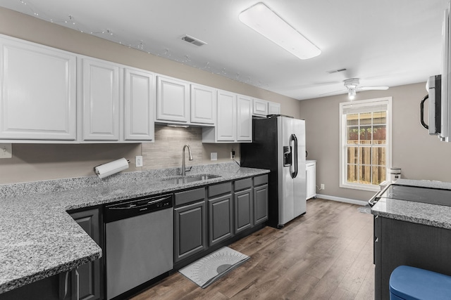 kitchen with appliances with stainless steel finishes, ceiling fan, sink, white cabinets, and dark hardwood / wood-style floors