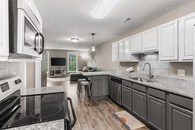 kitchen with stainless steel appliances, white cabinetry, and gray cabinetry