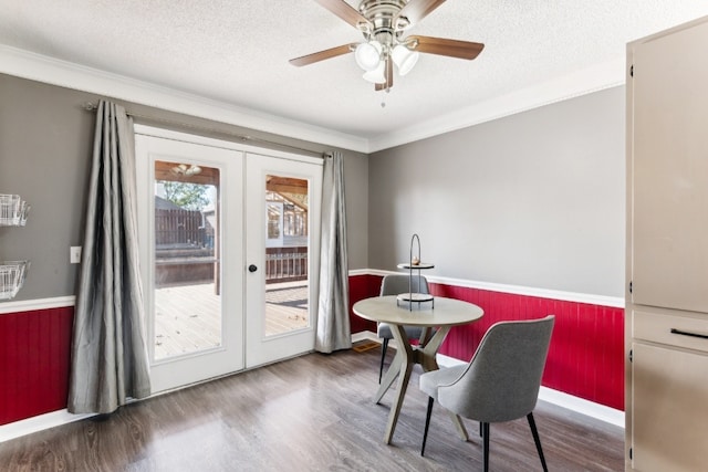 dining space with hardwood / wood-style floors, french doors, crown molding, ceiling fan, and a textured ceiling